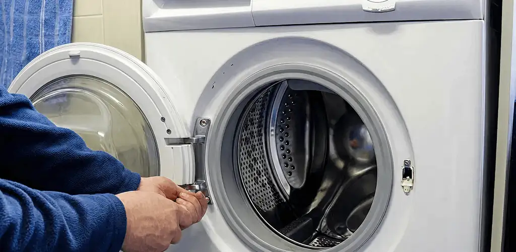 Washing machine repair handyman checking a front-load washer door and latch in Fresno, CA