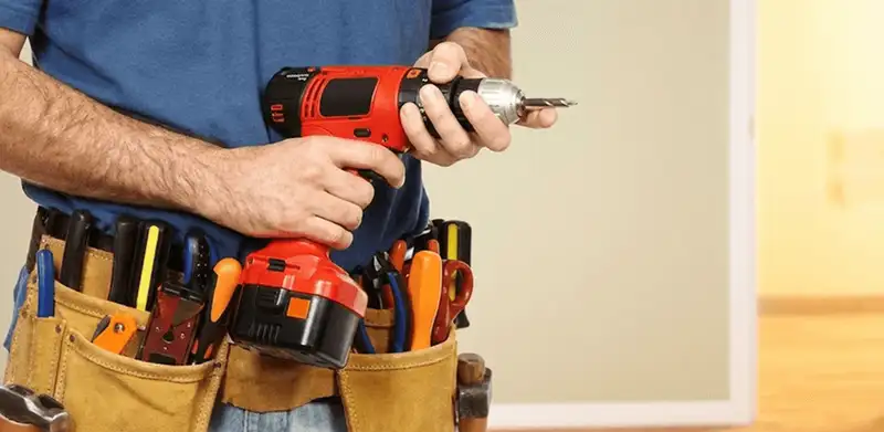 Handyman holding a power drill for home repairs and installations in Fresno, CA
