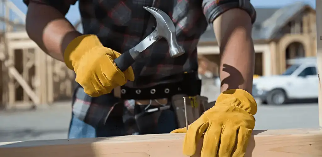 Handyman fixing wood trim with a hammer for home repairs in Fresno, CA