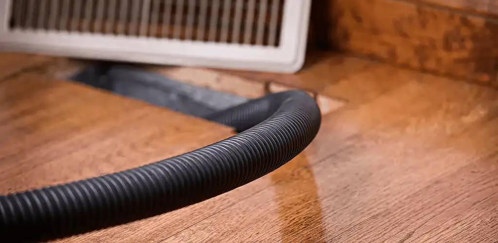 Air duct cleaning hose inserted into a floor vent for ductwork cleaning in Fresno, CA