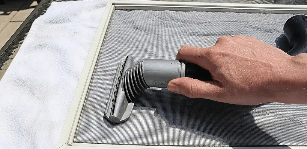 Window screen repair cleaning and fixing a damaged screen mesh in Fresno, CA